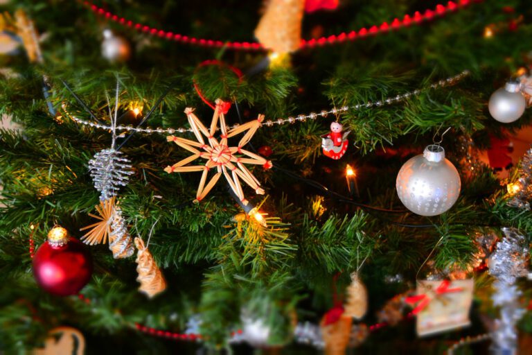 Weihnachtliches Motiv mit Tannen, Kugeln und Strohsternen
